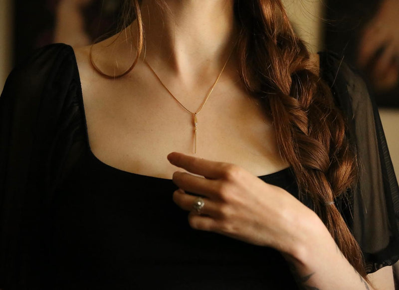 Model posing with Golden Luna Wand Pendant